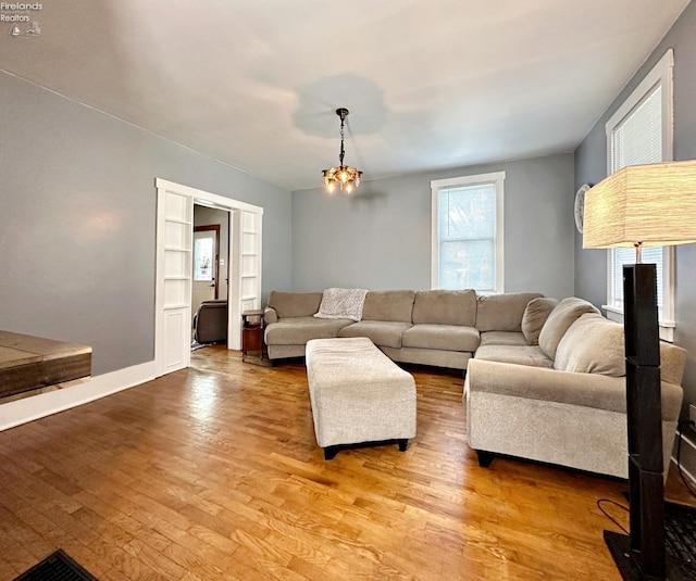 living room with hardwood / wood-style floors and a notable chandelier