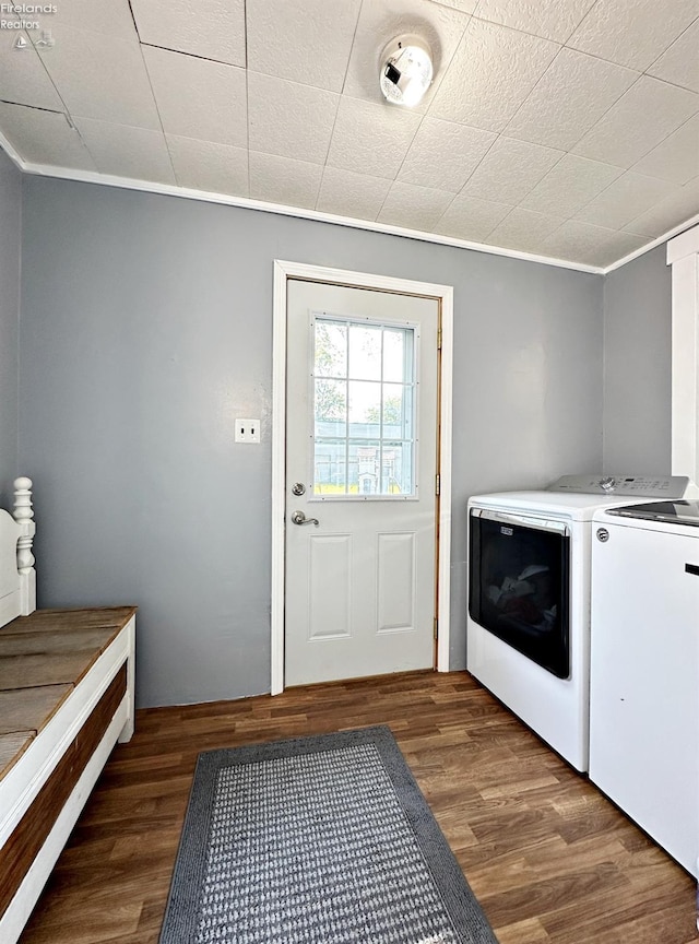 washroom featuring crown molding, dark hardwood / wood-style flooring, and washer and dryer