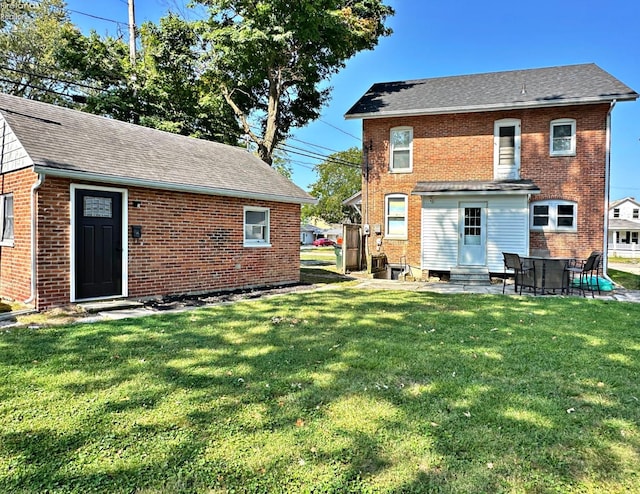 rear view of property with a yard and a patio