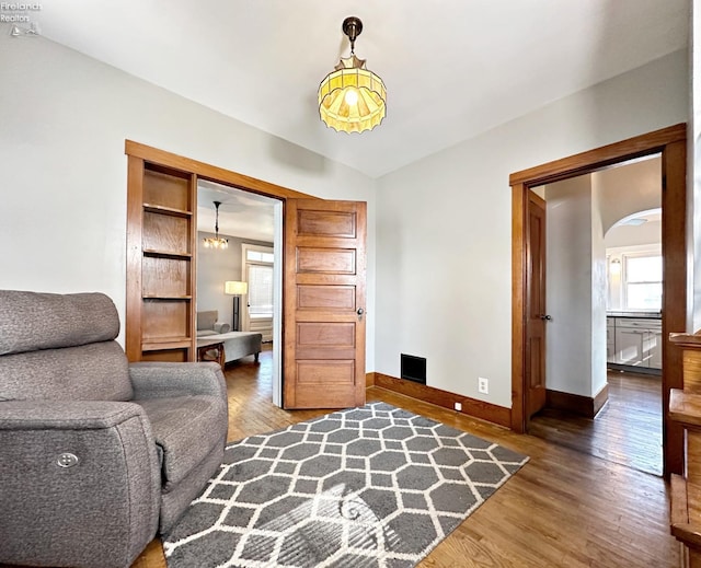 living area with vaulted ceiling and wood-type flooring