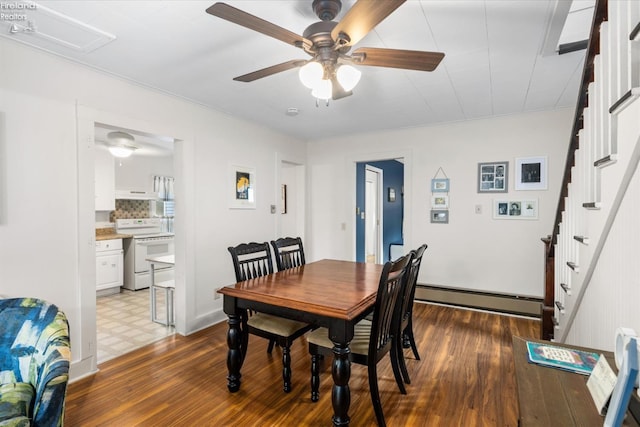 dining room featuring dark wood-type flooring, a baseboard radiator, and ceiling fan