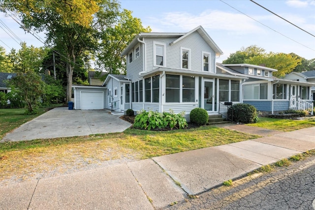 view of front facade with a garage, a sunroom, and a front yard