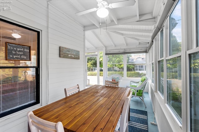 sunroom / solarium featuring ceiling fan and vaulted ceiling with beams