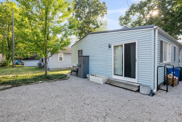 exterior space with cooling unit and a lawn