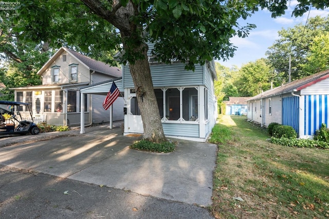 view of front of home featuring a front yard and a sunroom