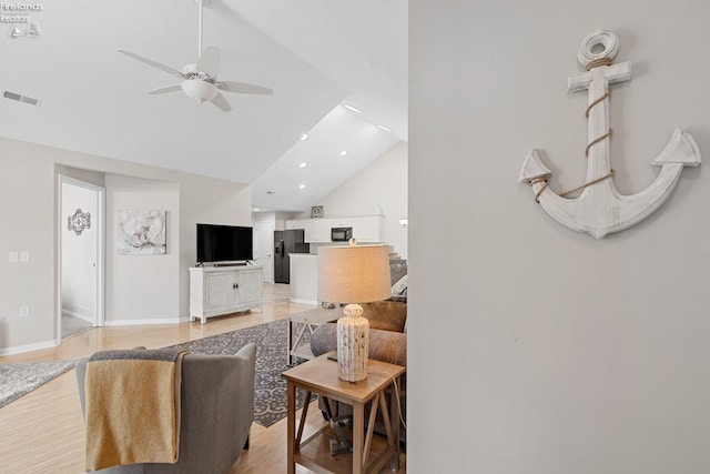 living room featuring light wood-type flooring, high vaulted ceiling, and ceiling fan