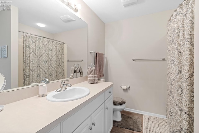 bathroom featuring vanity, toilet, and hardwood / wood-style floors