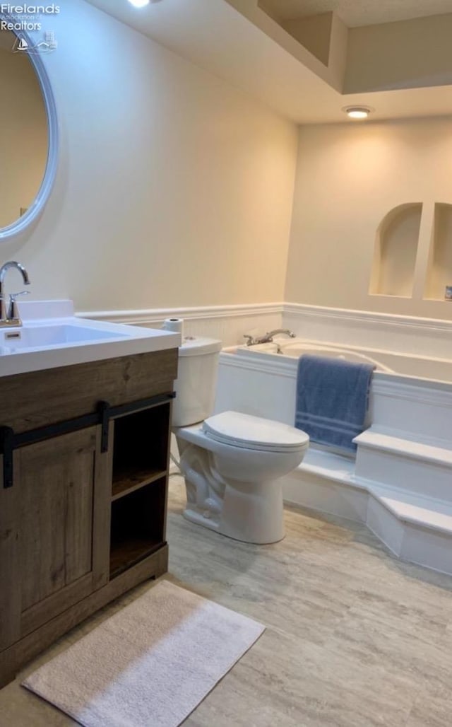 bathroom with hardwood / wood-style floors, vanity, and toilet