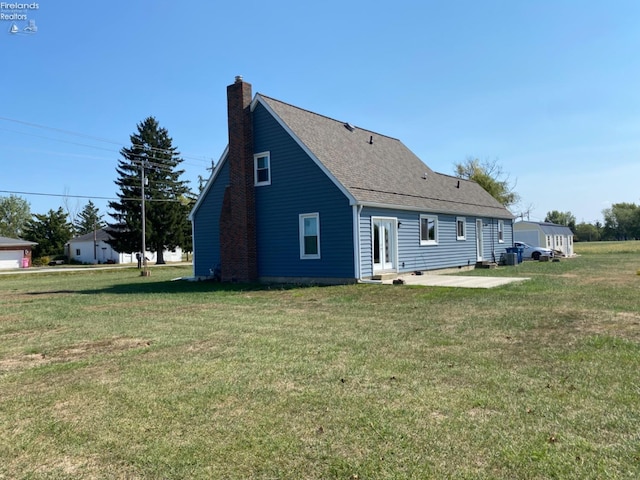 back of property with a yard and a patio area