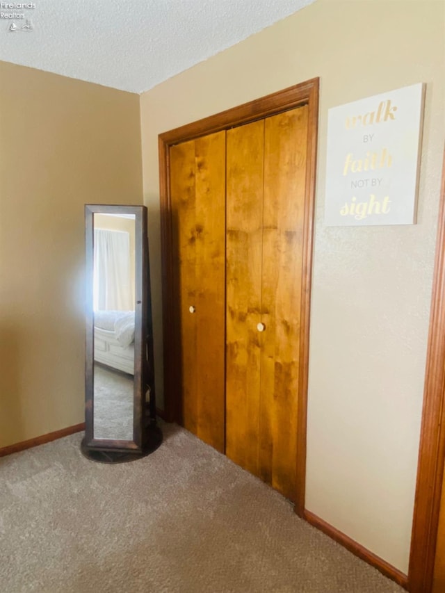 unfurnished bedroom with a closet, carpet, and a textured ceiling