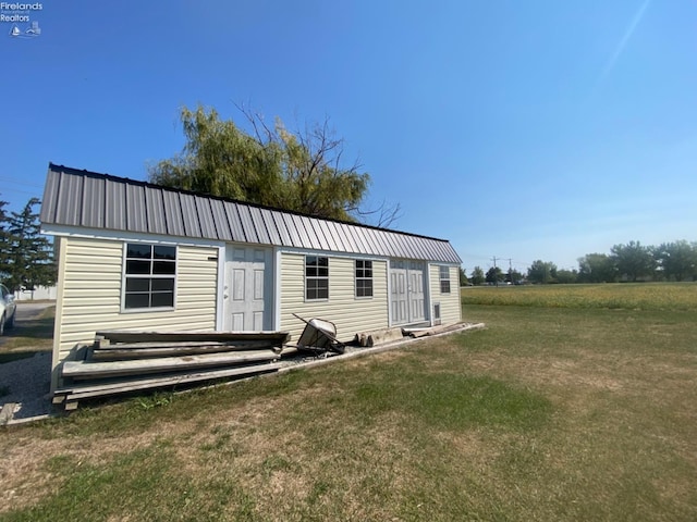 view of front facade featuring a front yard and an outbuilding