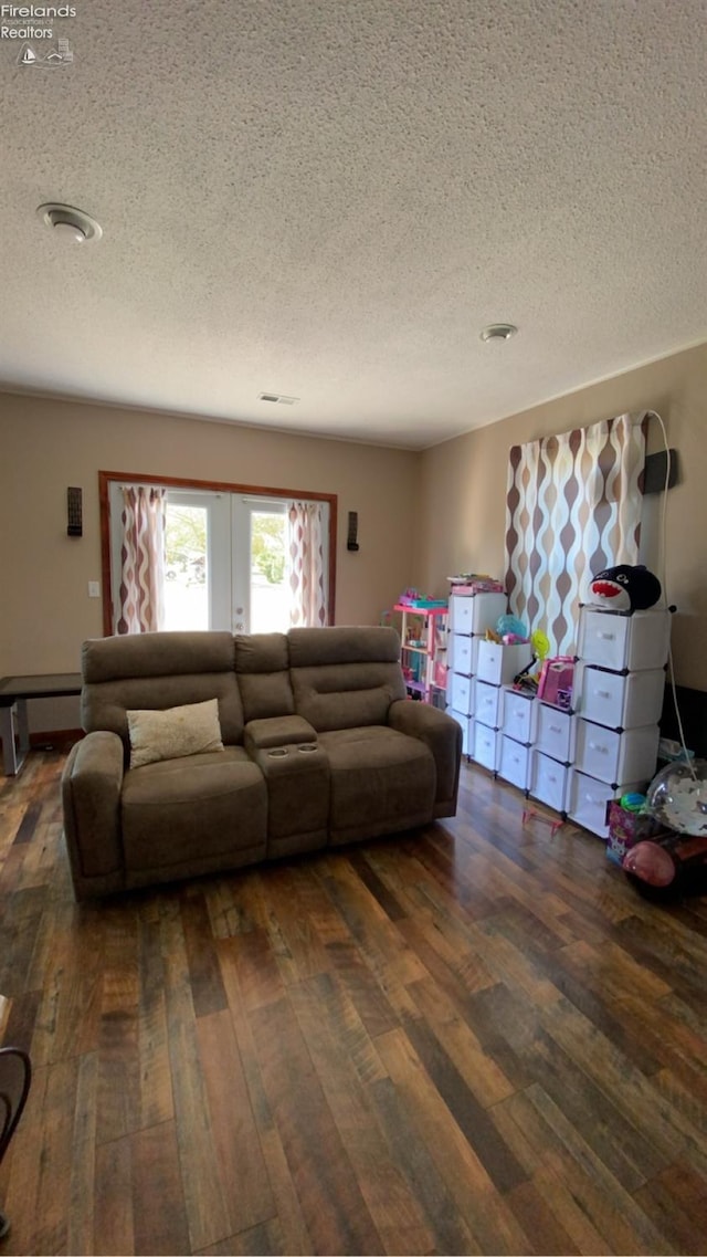 living room with a textured ceiling and dark hardwood / wood-style flooring