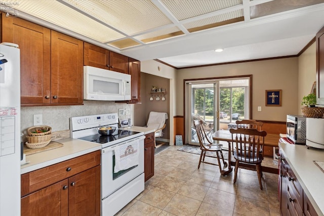 kitchen featuring crown molding, white appliances, light tile patterned floors, and backsplash