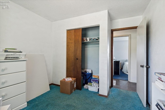 carpeted bedroom with a closet and a textured ceiling