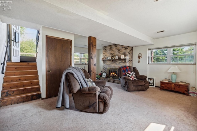 living room with a brick fireplace, carpet, and a healthy amount of sunlight