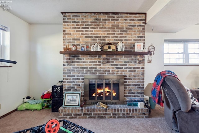 living room with carpet floors, a brick fireplace, and a wealth of natural light