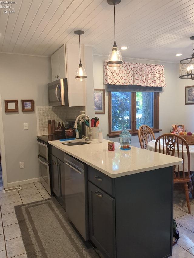 kitchen featuring appliances with stainless steel finishes, tasteful backsplash, hanging light fixtures, and sink