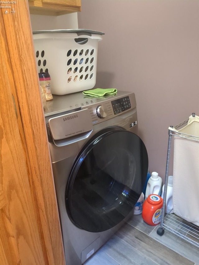 washroom featuring hardwood / wood-style flooring and washer / dryer