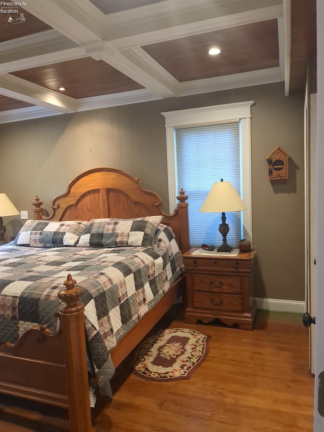 bedroom with beam ceiling, crown molding, coffered ceiling, and hardwood / wood-style flooring