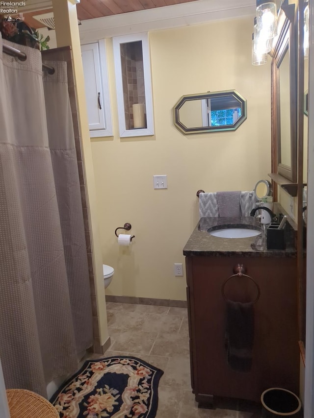 bathroom with tile patterned floors, vanity, toilet, and walk in shower