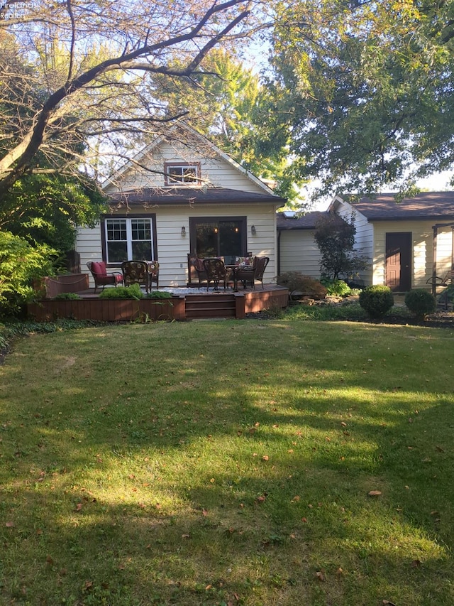 rear view of property featuring a wooden deck and a yard