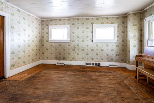 unfurnished room featuring a wealth of natural light, dark hardwood / wood-style floors, and crown molding