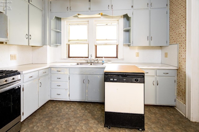 kitchen with stainless steel range with gas cooktop, white cabinetry, dishwasher, and sink