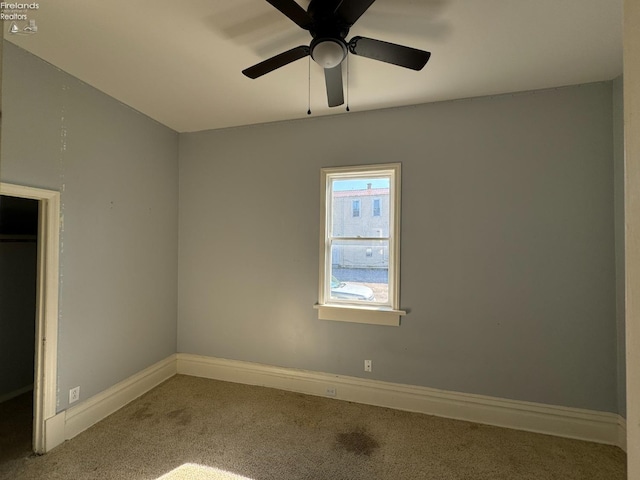 spare room featuring ceiling fan and carpet