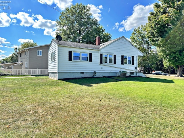 view of front of home featuring a front lawn and central AC