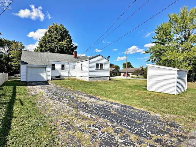 back of property featuring a garage, a storage shed, and a yard