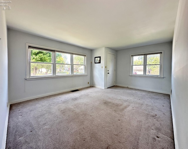 empty room with light carpet and a wealth of natural light