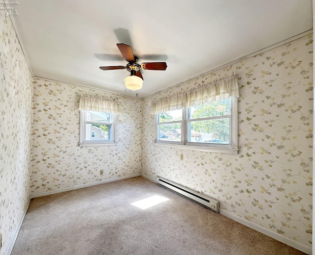 carpeted spare room with a baseboard heating unit, ceiling fan, and crown molding