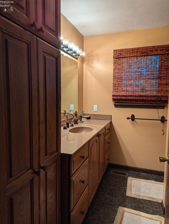 bathroom with a textured ceiling and vanity