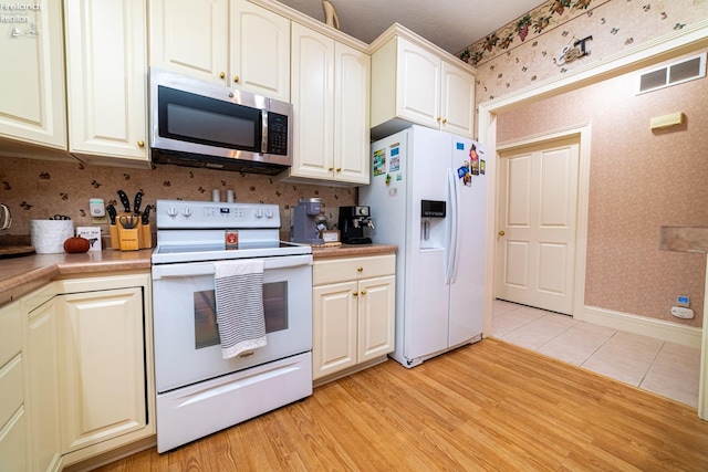 kitchen with white appliances and light hardwood / wood-style floors