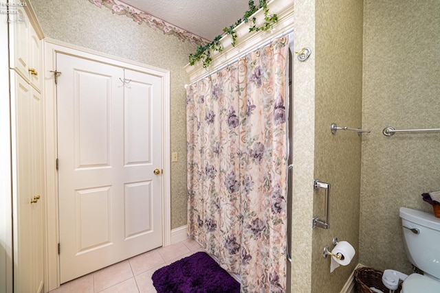 bathroom with walk in shower, a textured ceiling, toilet, and tile patterned floors