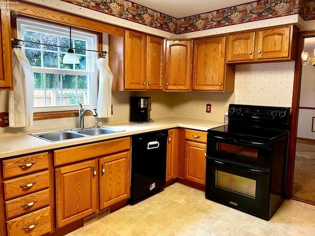 kitchen with black appliances, hanging light fixtures, and sink