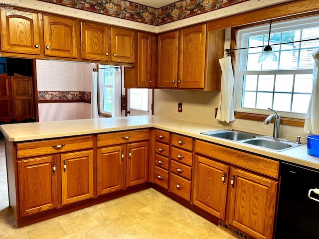 kitchen with dishwasher, hanging light fixtures, sink, and kitchen peninsula