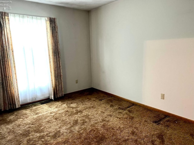 empty room with carpet floors and plenty of natural light