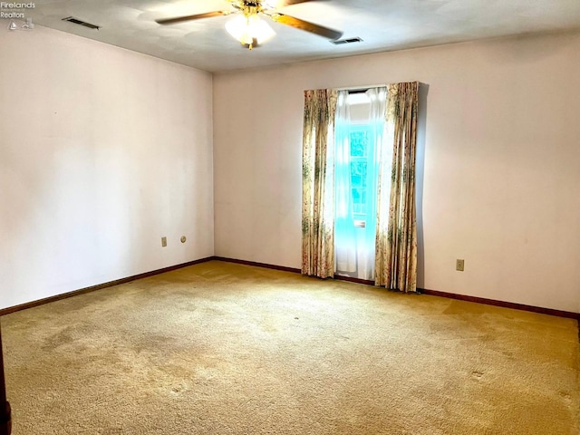 carpeted spare room featuring ceiling fan