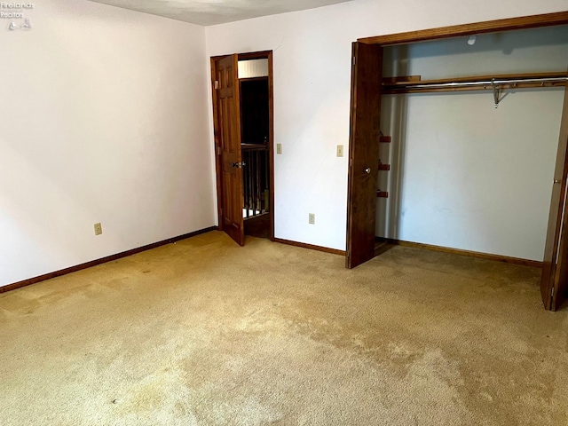 unfurnished bedroom featuring a closet and light colored carpet