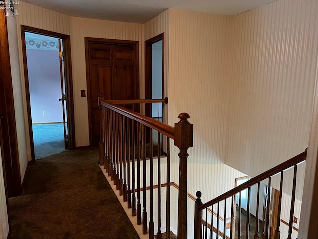 hall featuring dark colored carpet