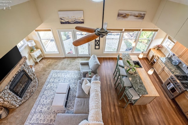 living room with high vaulted ceiling, ceiling fan, and hardwood / wood-style floors