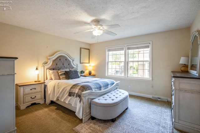 bedroom with ceiling fan, carpet floors, and a textured ceiling