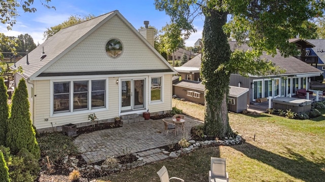 back of house featuring a yard, an outdoor fire pit, a wooden deck, and a patio area