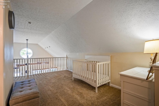 bedroom with carpet floors, a textured ceiling, lofted ceiling, and a crib