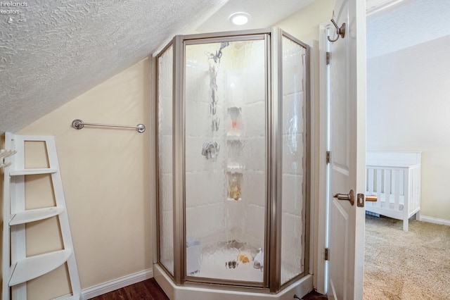 bathroom featuring lofted ceiling, a textured ceiling, and an enclosed shower