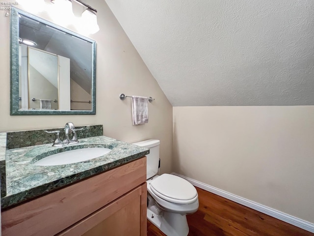 bathroom with vaulted ceiling, vanity, toilet, and hardwood / wood-style flooring