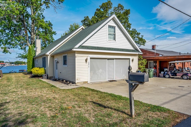 view of side of property with a lawn, a carport, and a garage