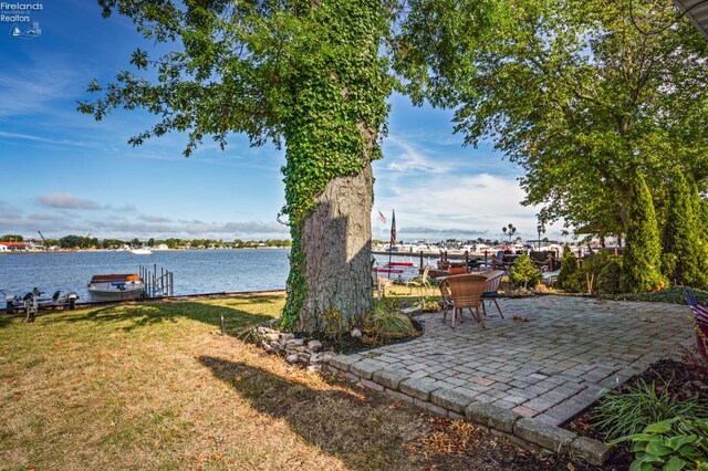 view of yard with a patio, a boat dock, and a water view