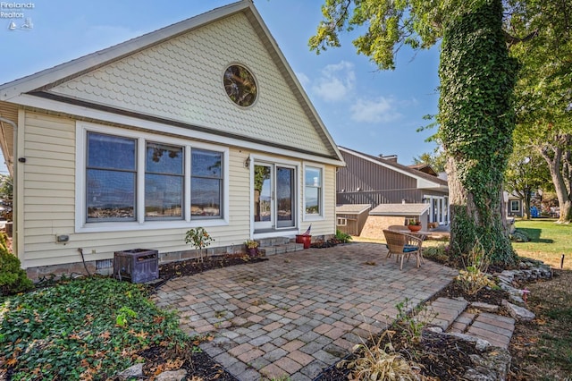 rear view of property with a patio area and central AC